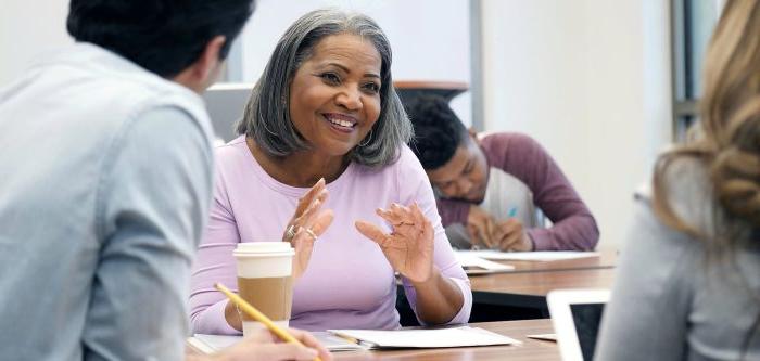 A female professor teaching student about a topic.