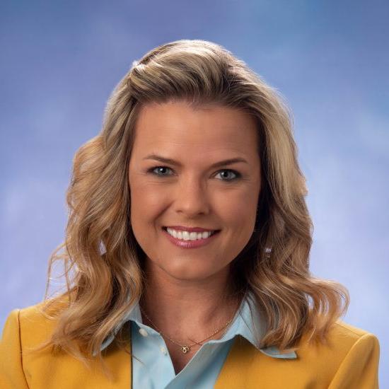 Head shot of Amanda Horne in yellow jacket and blue button-down shirt.